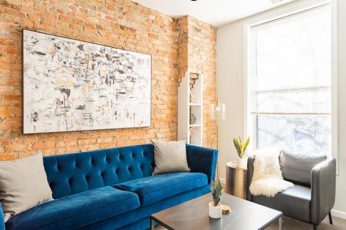 a blue couch in a living room with a brick wall at Walker's Paradise 1BR Apartment in Lincoln Park - Lincoln 2501 in Chicago