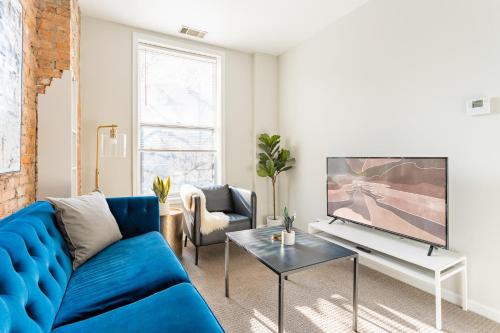 a living room with a blue couch and a tv at Walker's Paradise 1BR Apartment in Lincoln Park - Lincoln 2501 in Chicago