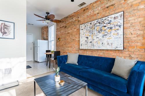 a living room with a blue couch and a brick wall at Walker's Paradise 1BR Apartment in Lincoln Park - Lincoln 2501 in Chicago