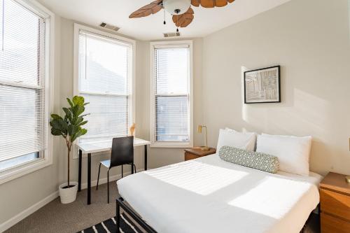 a bedroom with a bed and a desk and windows at Walker's Paradise 1BR Apartment in Lincoln Park - Lincoln 2501 in Chicago