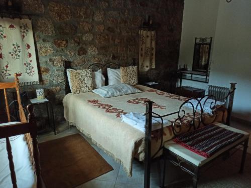 a bedroom with a bed and a stone wall at Casa da Azenha in Sortelha