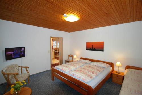 een slaapkamer met een bed en een houten plafond bij Gaestehaus-Achtern-Diek-Wohnung-10 in Süderhöft