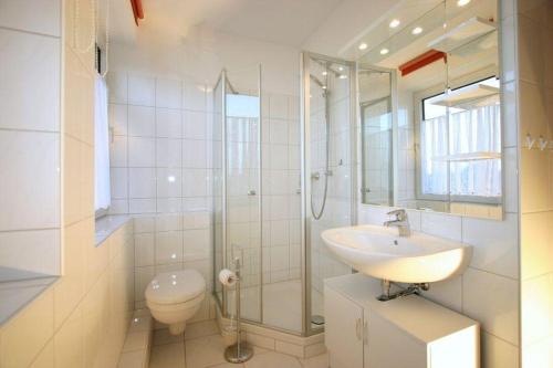 een badkamer met een wastafel, een douche en een toilet bij Gaestehaus-Achtern-Diek-Wohnung-10 in Süderhöft