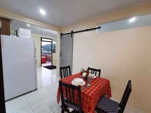 a dining room with a table with a red table cloth at flamboyantvilla in Gros Islet