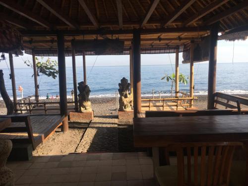 a view of the beach from a restaurant with benches at Amed Sunset Beach in Amed