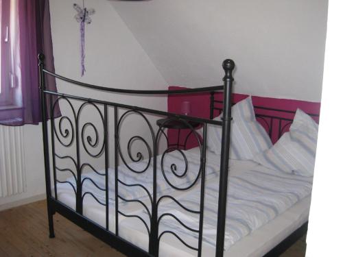 Bett mit schwarzem Rahmen und weißer Bettwäsche in der Unterkunft Ferienwohnungen Frank in Cochem
