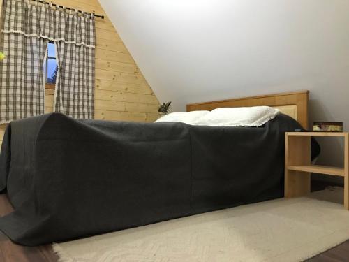 a bedroom with a bed with a black blanket at Planinski biser Mokra Gora in Mokra Gora
