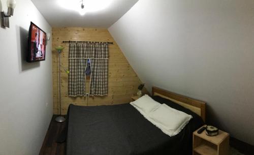 a small bedroom with a bed and a window at Planinski biser Mokra Gora in Mokra Gora