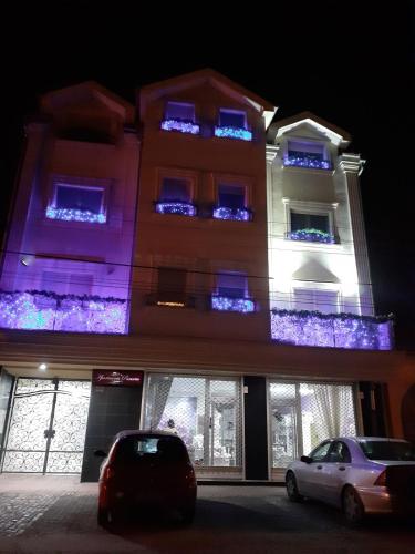 a building with blue lights on the windows at night at Apartments Soleado in Pančevo