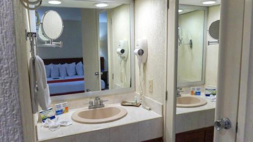 een badkamer met 2 wastafels en 2 spiegels bij HOTEL BRISA Coatzacoalcos in Coatzacoalcos