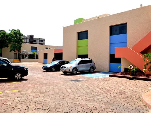 two cars parked in a parking lot in front of a building at HOTEL BRISA Coatzacoalcos in Coatzacoalcos