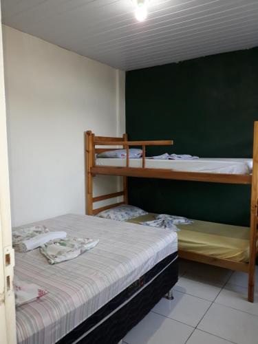 2 literas en una habitación con una pared verde en Casa acolhedora - aluguel por temporada, en Lençóis