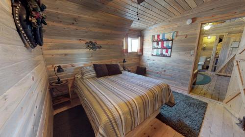 a bedroom with a bed in a wooden cabin at Canyonlands Barn Cabin with Loft, Full Kitchen, Dining Area for Large Groups in Verdure