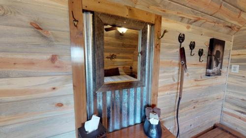 un miroir sur le mur d'une cabine en bois dans l'établissement Canyonlands Barn Cabin with Loft, Full Kitchen, Dining Area for Large Groups, à Verdure