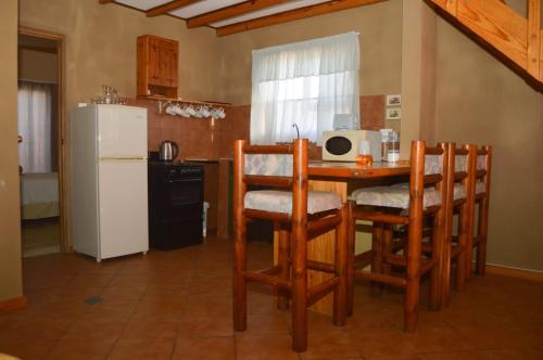 a kitchen with a table and chairs and a refrigerator at Khoinonia Guesthouse in Port Nolloth