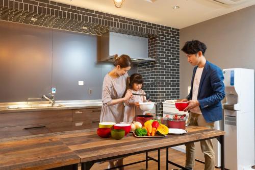a family standing in a kitchen preparing food at Kotohira Park Hotel in Kotohira