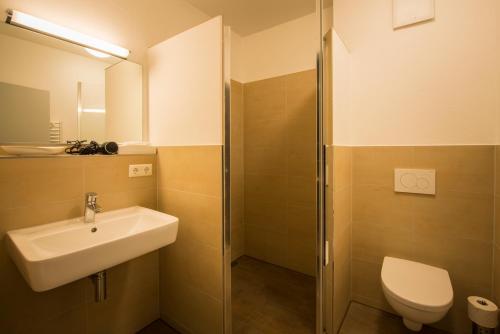 uma casa de banho com um lavatório, um WC e um chuveiro em Hotel Viva Bröckel em Bröckel