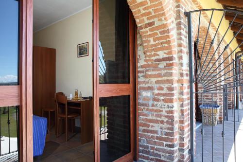 a room with a brick wall and a balcony at Al Casale B&B in Cherasco