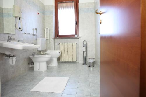 a bathroom with two toilets and a sink and a window at Al Casale B&B in Cherasco