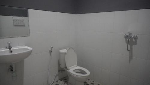 a bathroom with a toilet and a sink at JOGLO Greenhouse in Ngemplak