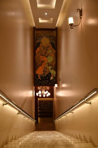 a staircase in a building with a painting on the wall at Pristine Hotel, Varanasi in Varanasi