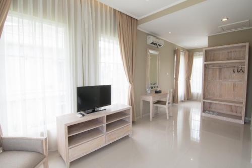 a living room with a flat screen tv on a cabinet at Sevilla Resort Magelang in Magelang