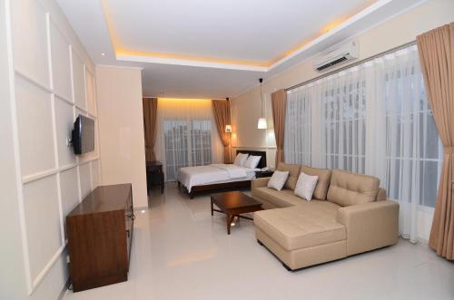 a living room with a couch and a bed at Sevilla Resort Magelang in Magelang