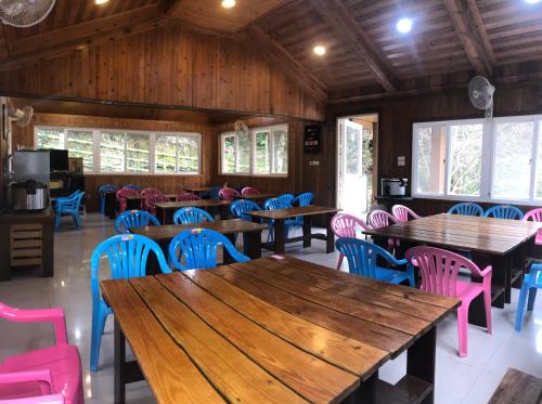 een eetkamer met houten tafels en kleurrijke stoelen bij Xijing Ecological Farm in Hualing