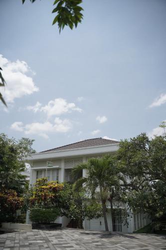 a white building with trees in front of it at Sevilla Resort Magelang in Magelang