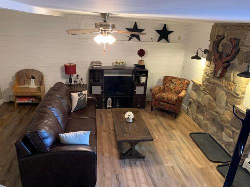 a living room with a leather couch and a table at Myers Chalet in Ellicottville