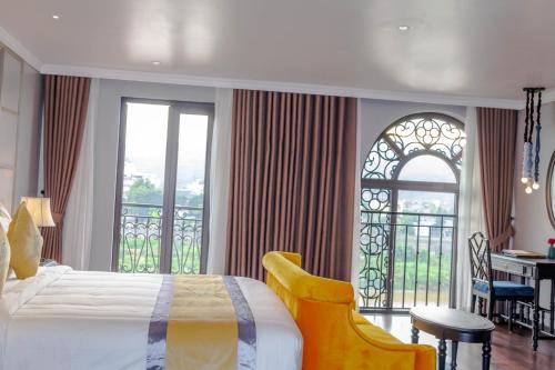a bedroom with a bed and a balcony with a desk at Michi's hotel laocai in Lao Cai