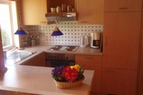 a kitchen with a basket of flowers on a counter at Luetjens-Bienenhaus in Ulsnis