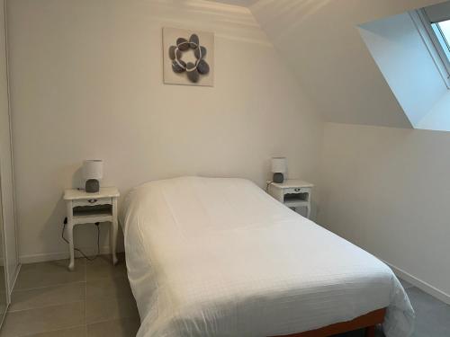 - un lit blanc dans une chambre avec deux tables dans l'établissement la petite loge, à Ay