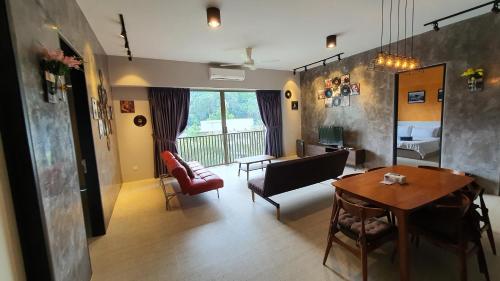 a living room with a couch and a table at By The Sea Beach Luxury Resort - Batu Ferringhi in Batu Ferringhi
