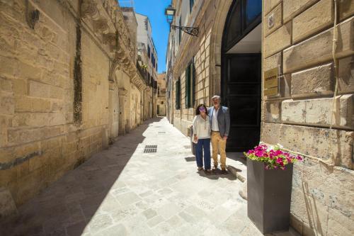 a man and a woman standing in an alley at Dimora San Leucio in Lecce