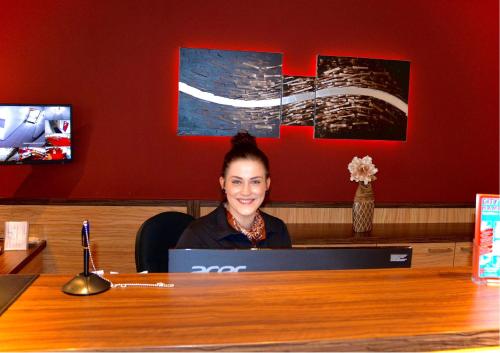 a woman sitting at a desk with a laptop at Hotel Harburger Hof in Hamburg