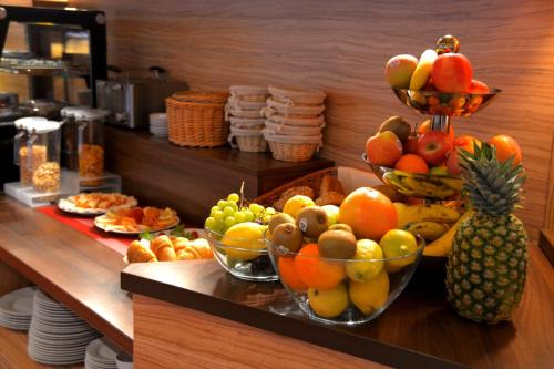 a buffet with bowls of fruit on a counter at Hotel Harburger Hof in Hamburg