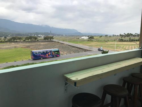 a blue bus driving down a road with a view at 池上5159懷舊民宿 請勿用阿勾達訂房 in Chishang