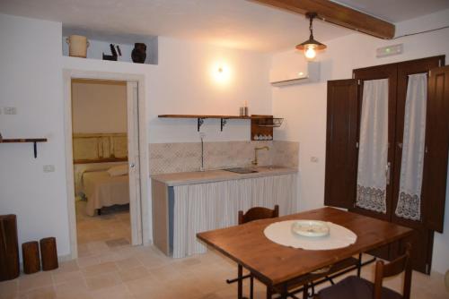 卡斯特拉納格羅泰的住宿－Trulli don Pietro，厨房以及带桌子和水槽的用餐室