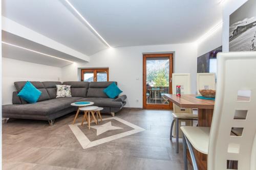 ein Wohnzimmer mit einem Sofa und einem Tisch in der Unterkunft Ferienwohnung Steinplatte in Waidring