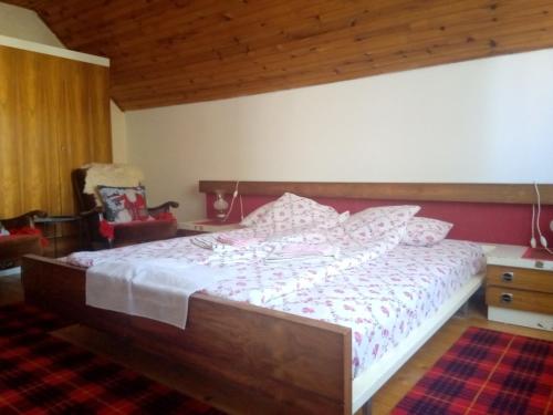 a bedroom with a large bed with a wooden headboard at Studio Krejović sa zasebnim kupatilom i čajnom kuhinjom in Zlatibor