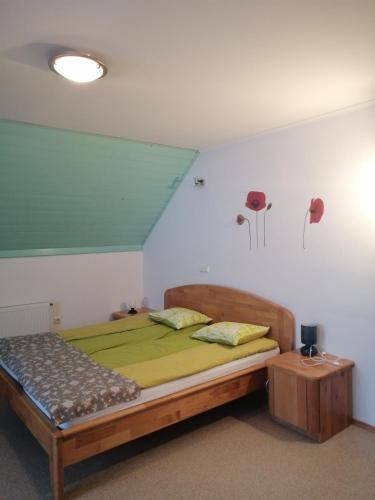 a bedroom with a bed with green sheets and a blue ceiling at Apartment Korošec Matej in Bohinj