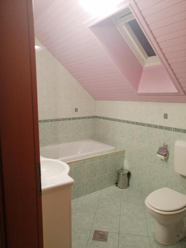a bathroom with a tub and a toilet and a sink at Apartment Korošec Matej in Bohinj