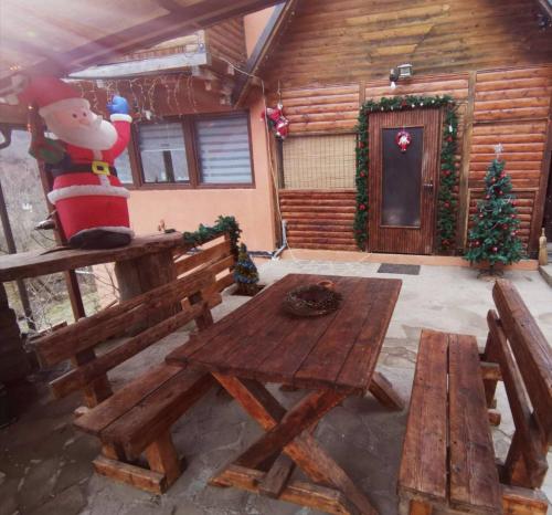 a room with a picnic table and a santa claus statue in a cabin at Planinska IDILA in Crni Vrh
