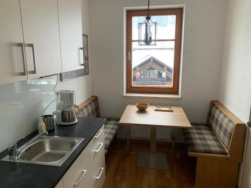 a small kitchen with a table and a window at Dachstein Mountainview Gosau in Gosau