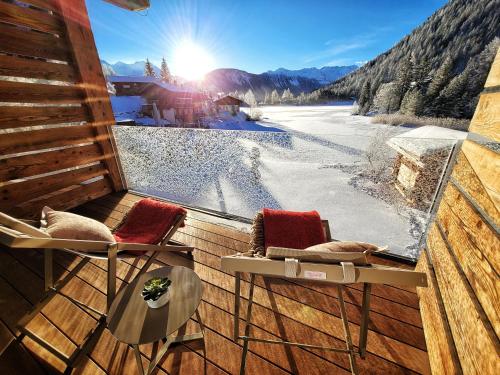 a balcony with two chairs and a table and a view at Au Club Alpin in Champex