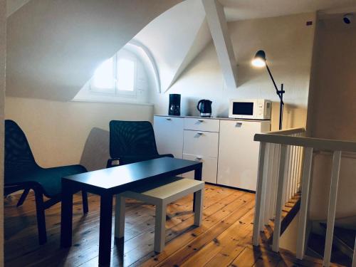 a room with a table and chairs and a kitchen at Ela Apartments Berlin in Berlin