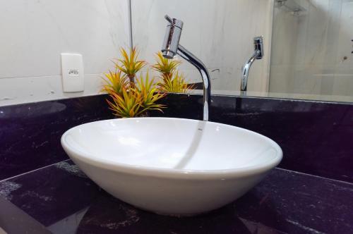 a white bowl sink with a faucet in a bathroom at Ananda Pousada in Pirenópolis