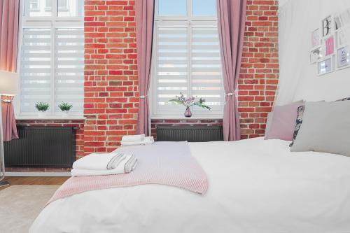 - un lit blanc dans une chambre dotée d'un mur en briques dans l'établissement Princess Dream apartment in the heart of Wroclaw, à Wrocław