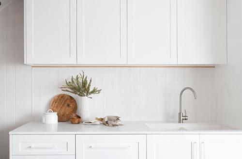a kitchen counter with white cabinets and a sink at Crystal Pacific Palm Beach in Gold Coast
